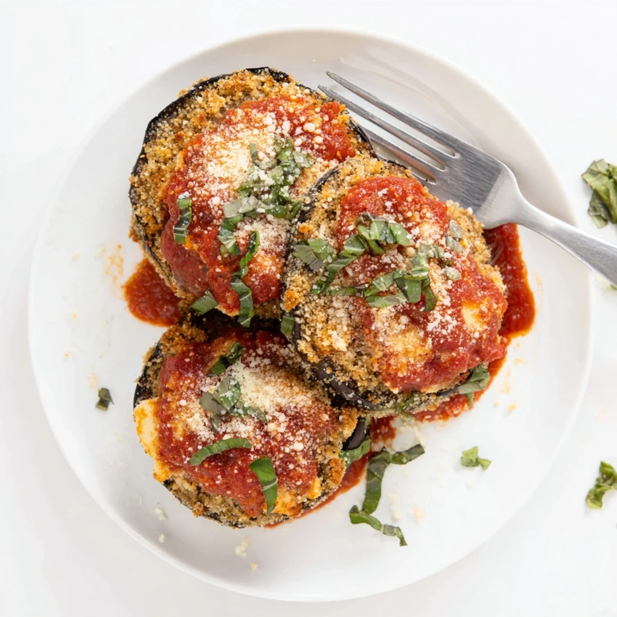Homemade eggplant parmesan with golden breadcrumbs and gooey cheese layers, paired with crusty bread on the side.