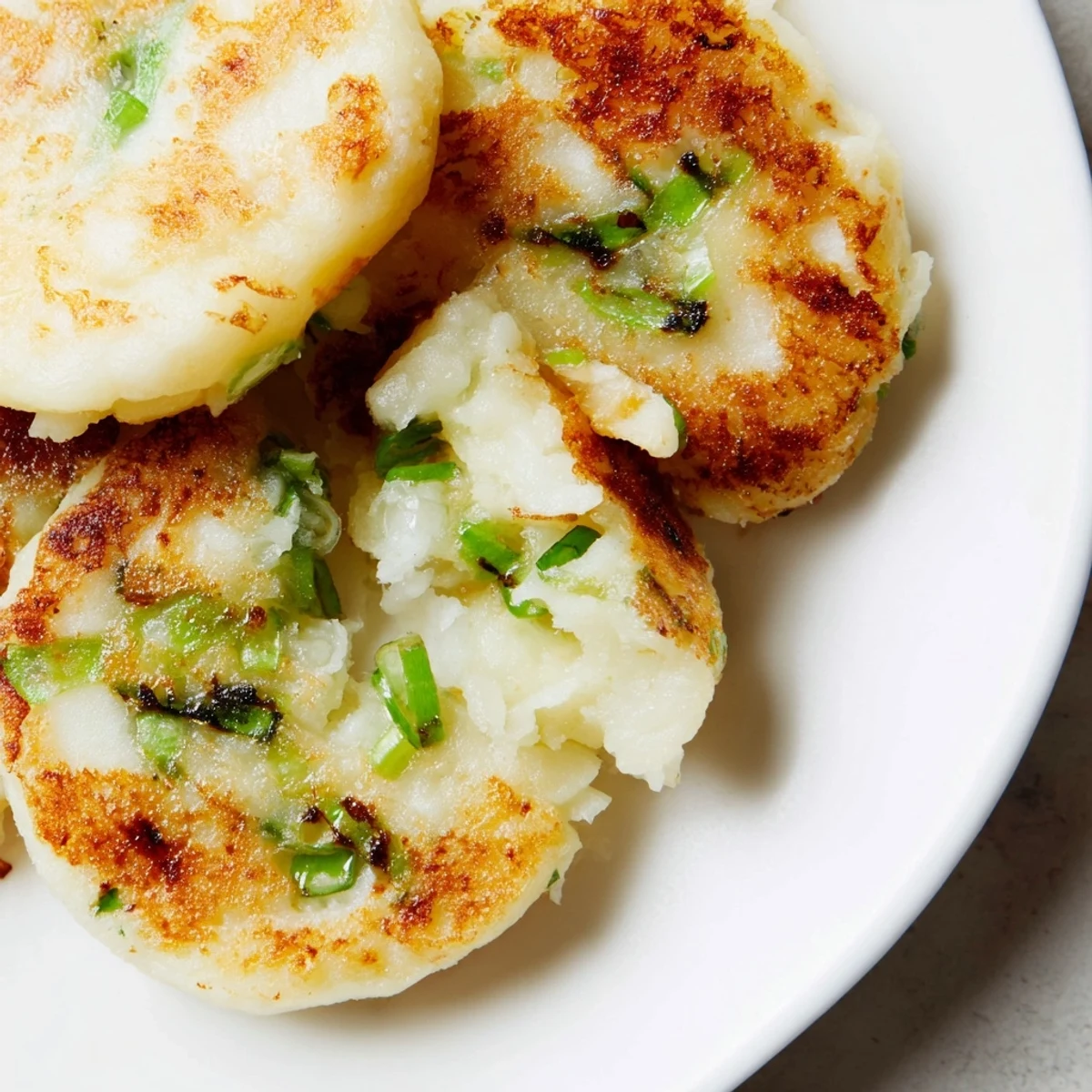 Homemade Irish Potato Cakes with Scallions on a rustic plate with butter.