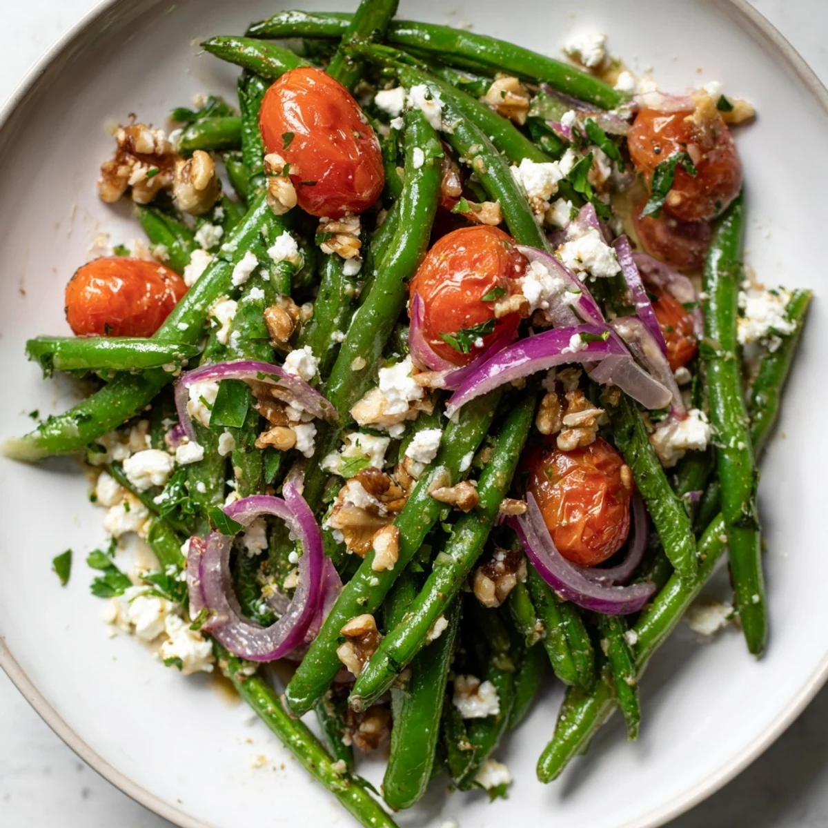 A chilled Green Bean Salad with Feta is topped with crunchy walnuts and parsley for serving.
