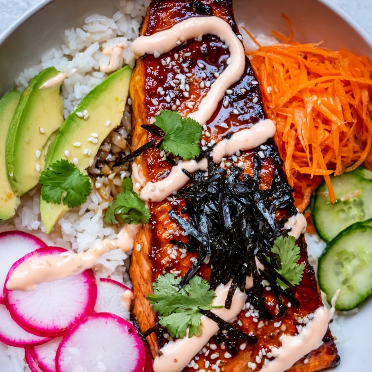 Jasmine rice and glazed salmon loaded with avocado, scallions, sesame seeds, nori, and pickled vegetables in a bowl.