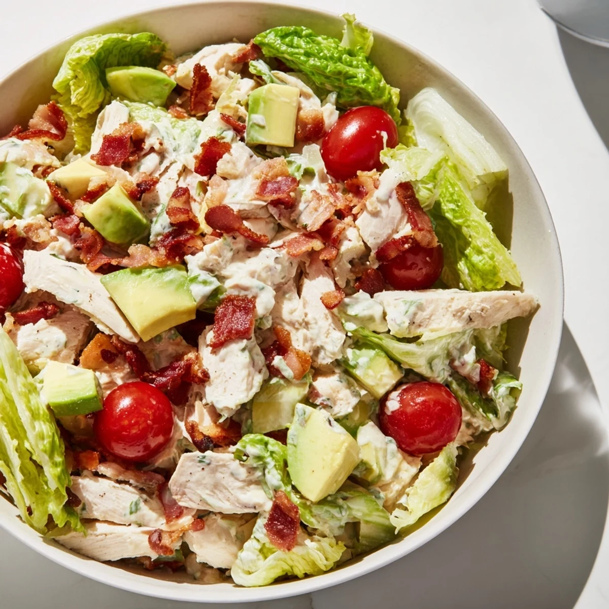 BLT Chicken Salad with juicy chicken, crispy bacon, ripe tomatoes, and crunchy romaine in a creamy dressing.