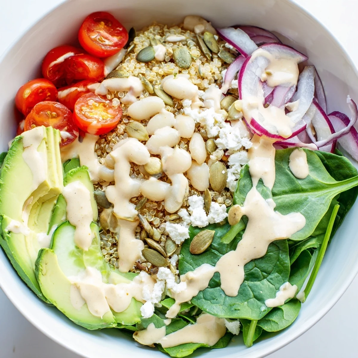Ready-to-serve Spinach & White Bean Ultimate Protein Power Bowl with cherry tomatoes, red onion, and feta crumbles, perfect for a nutritious vegetarian lunch.