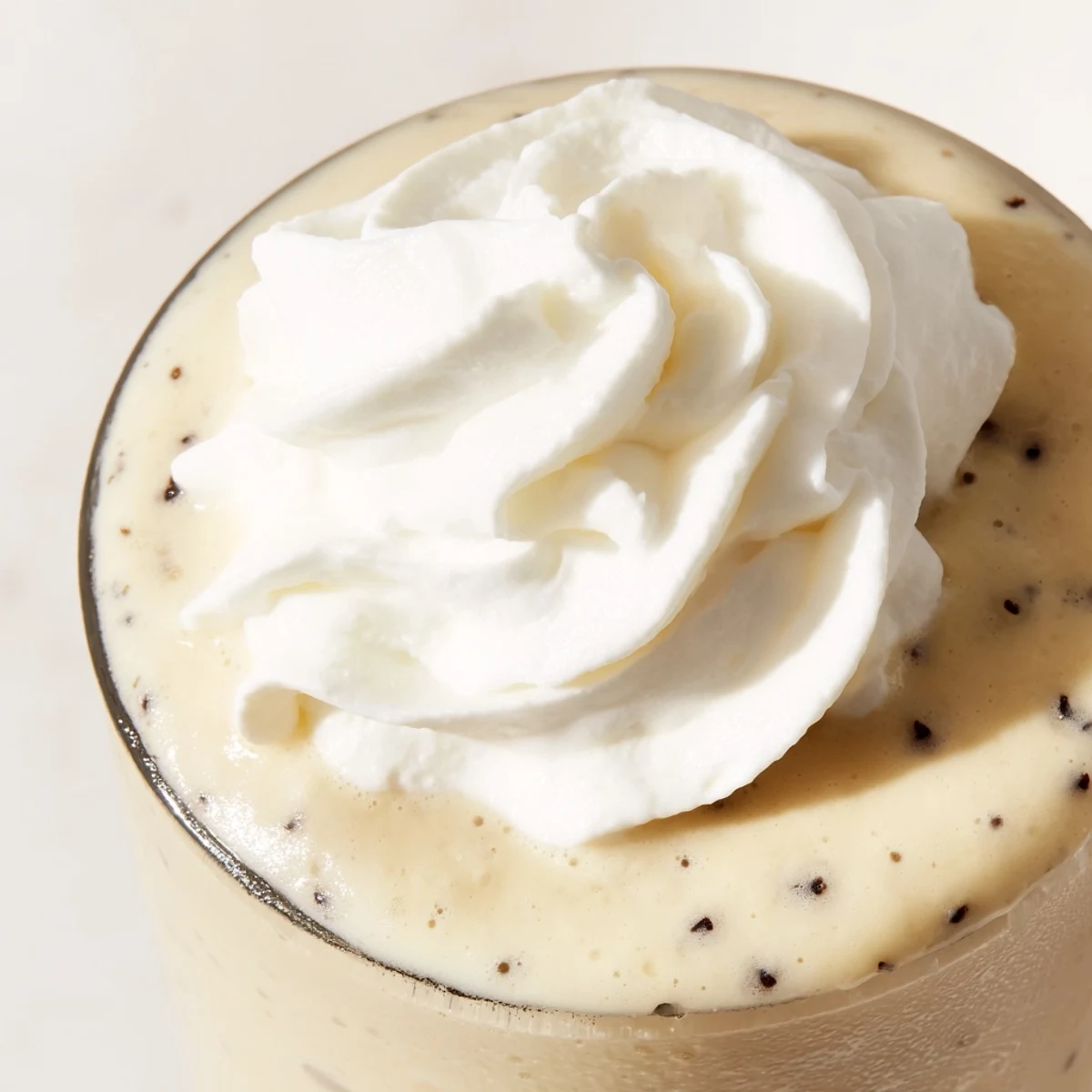 Starbucks Vanilla Bean Frappuccino blended with ice and milk, served in a glass with a straw for sipping.