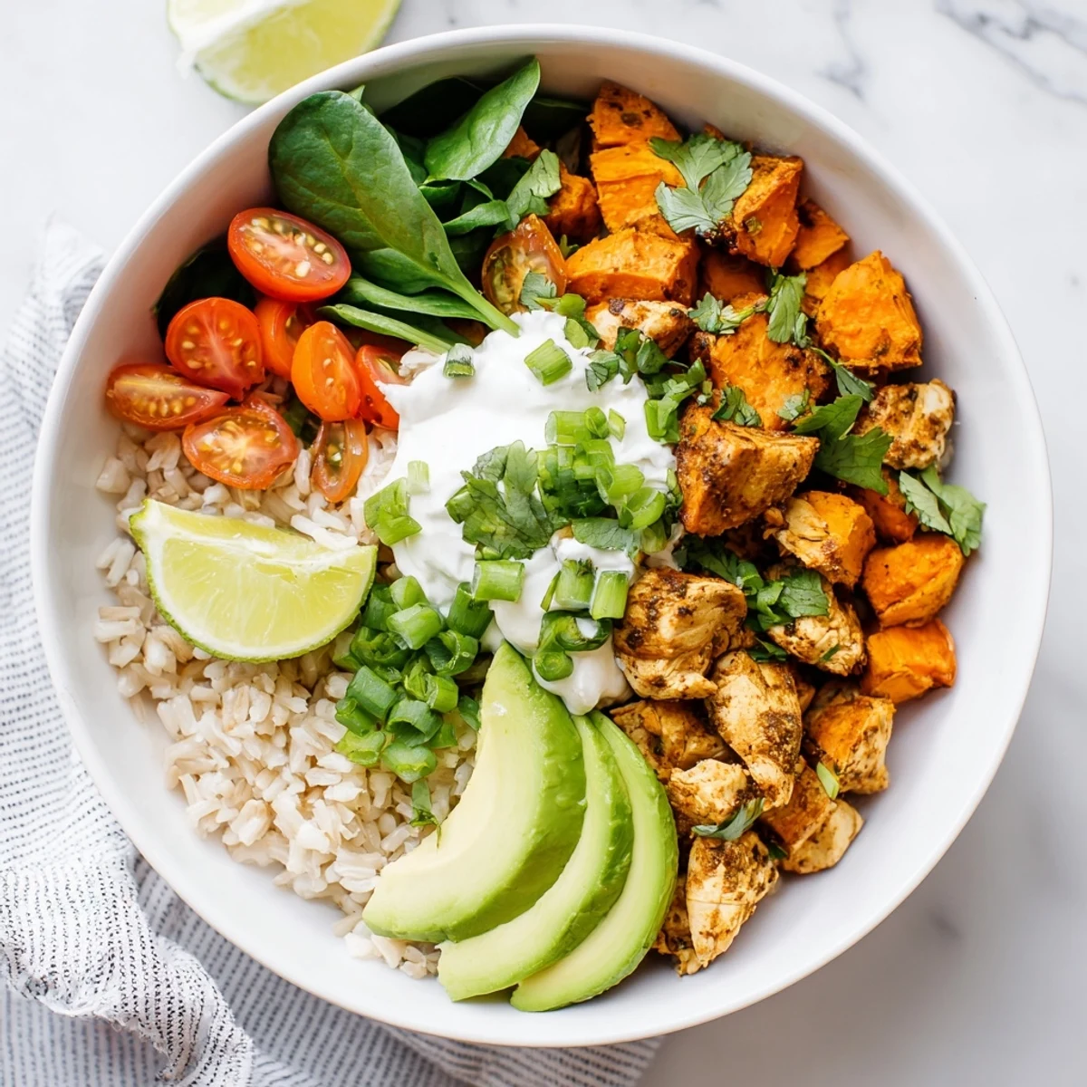 A vibrant Wholesome Chicken Sweet Potato Rice Bowl with roasted chicken, golden sweet potatoes, fluffy rice, fresh avocado, and a creamy yogurt drizzle.