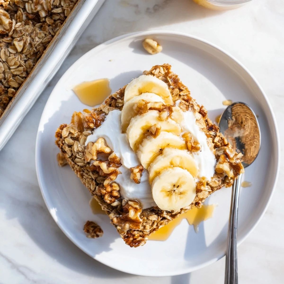 Cozy breakfast bowl of Banana Baked Oatmeal served with Greek yogurt and fresh banana slices for a comforting morning meal.