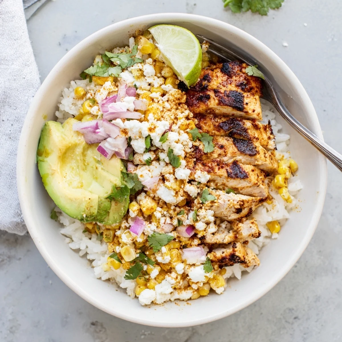 Hearty street corn chicken rice bowl topped with charred corn juicy chicken and fresh cilantro
