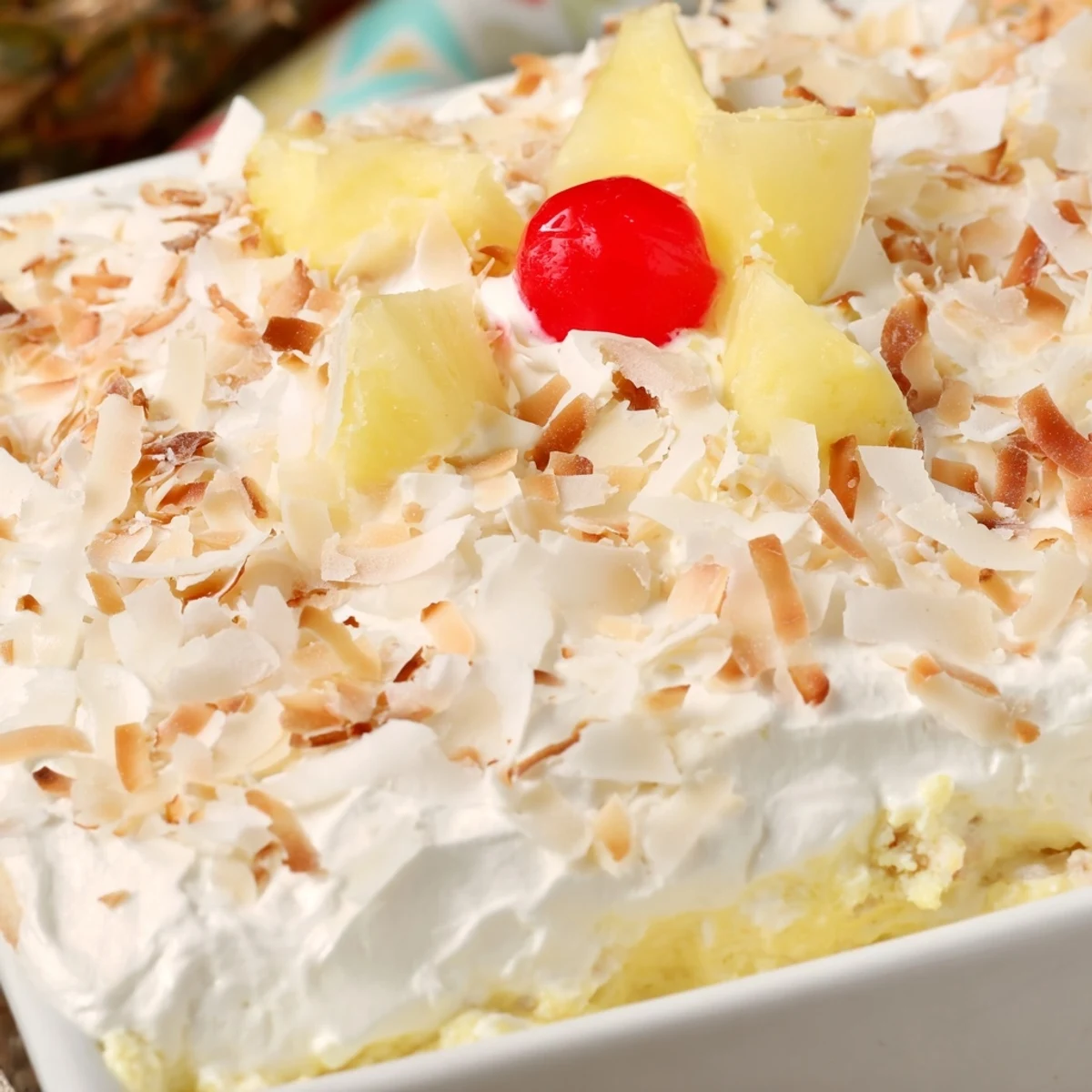Moist Hawaiian poke cake with pineapple pudding filling and whipped topping garnish