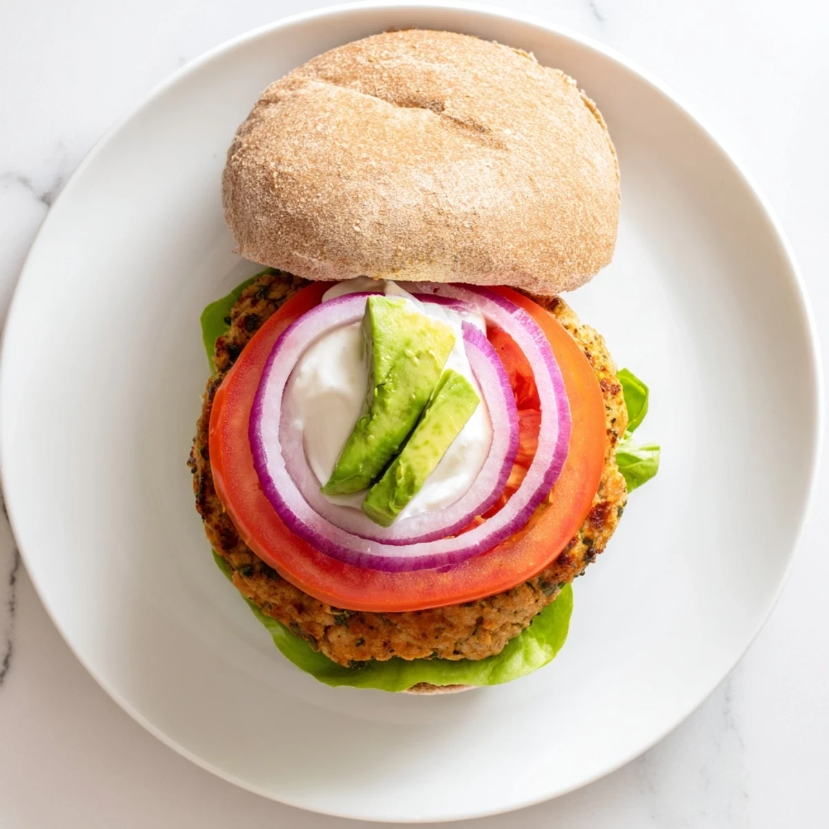 Juicy healthy high protein burger with lettuce tomato onion on toasted whole wheat bun