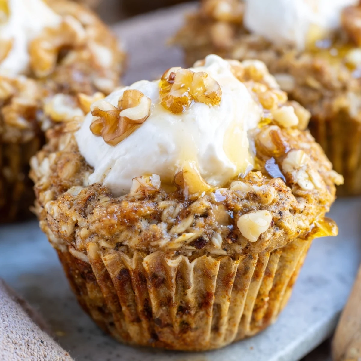 Fluffy oatmeal cups with mashed banana slices and tangy yogurt topping served warm