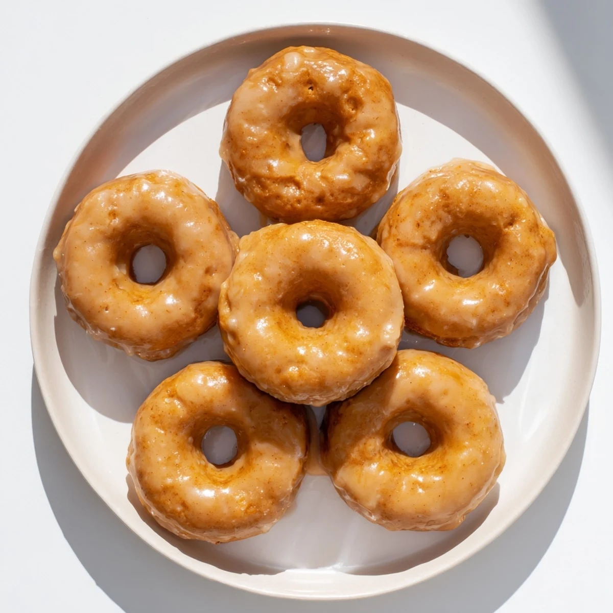 Glaze-dipped maple pumpkin mochi donuts showing soft chewy texture with autumn spice flecks