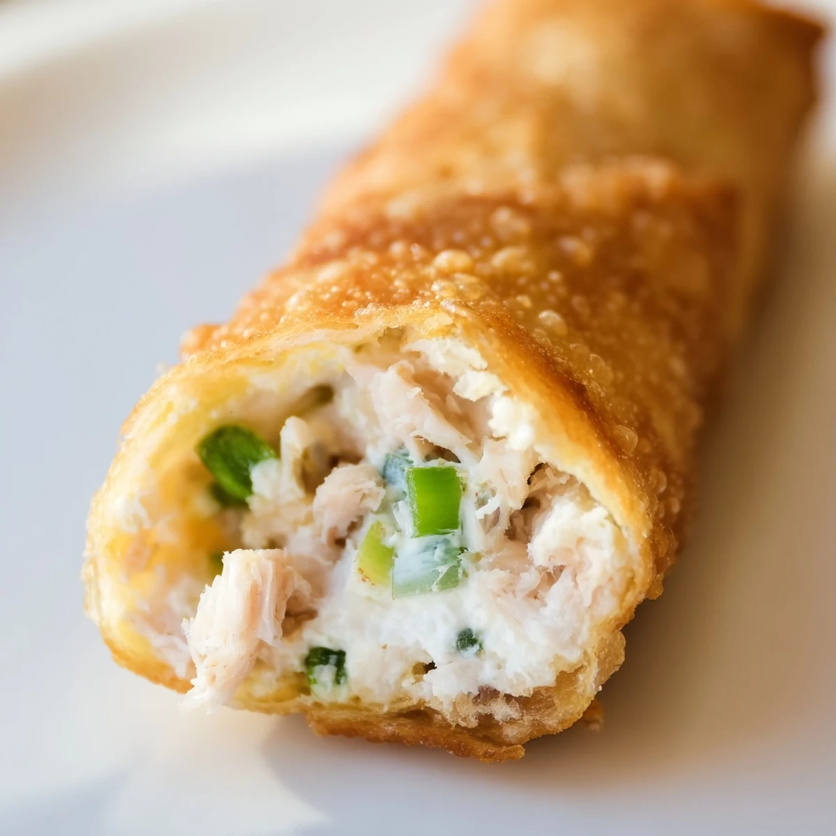 Golden brown Crab Rangoon egg rolls with creamy crab filling on a serving platter