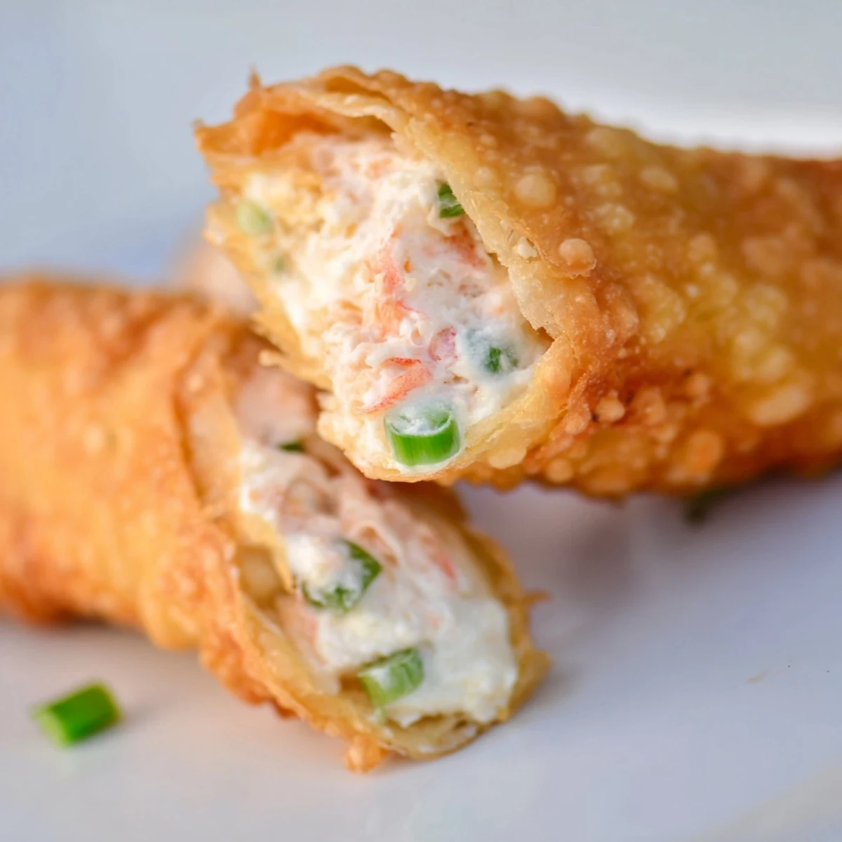 Crispy fried egg rolls stuffed with savory cream cheese and crab meat appetizer