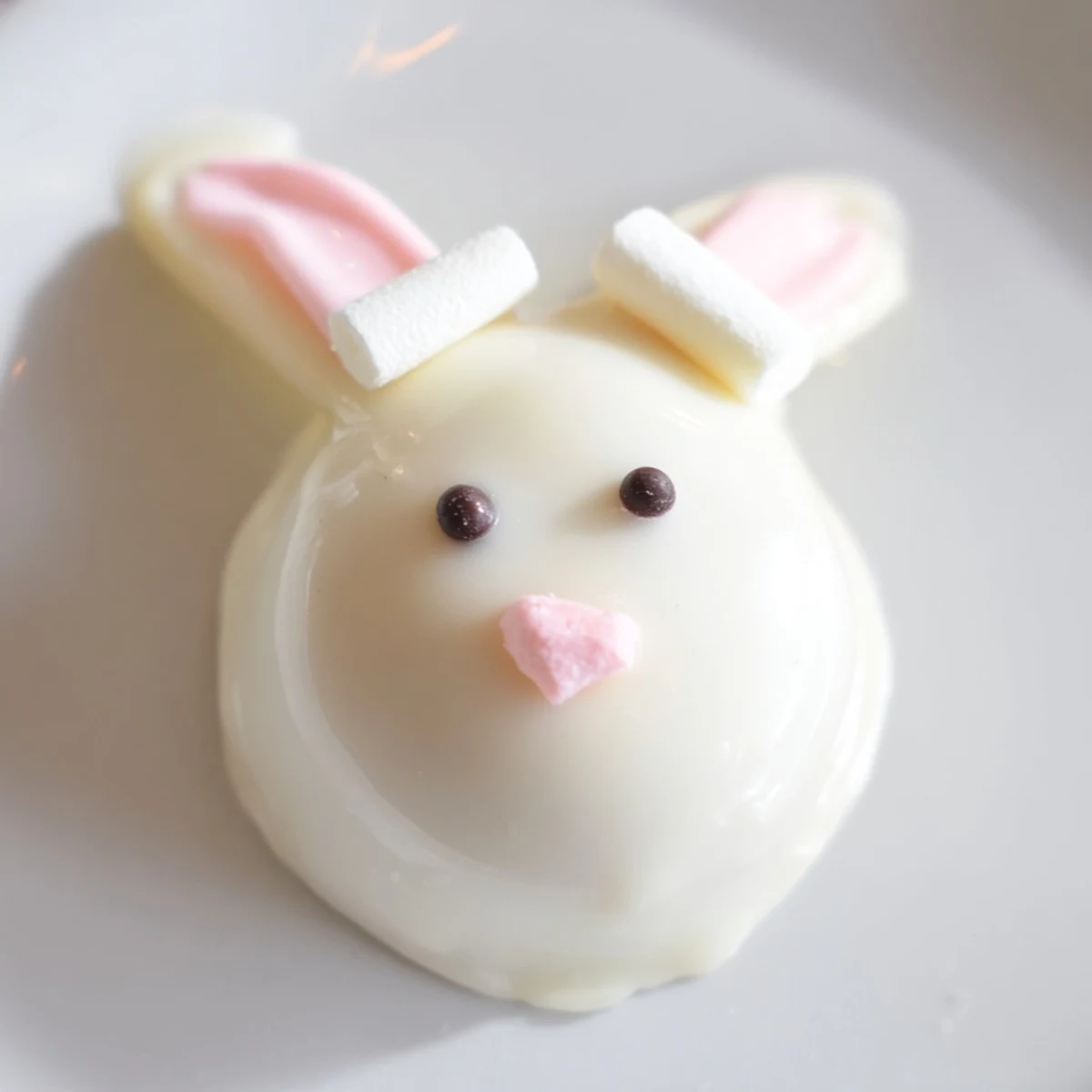 Adorable white chocolate bunny Oreo balls decorated with pink ears and marshmallow tails