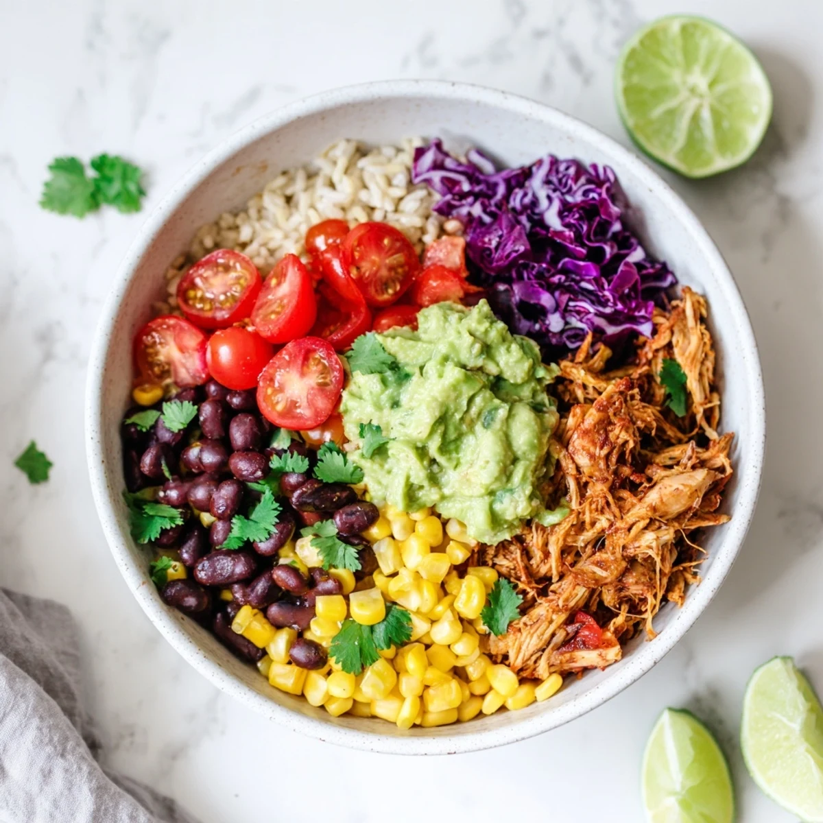 Vibrant Pulled Chicken Guacamole Bowl with tender spiced chicken, creamy avocado, and colorful Tex-Mex toppings over fluffy rice.