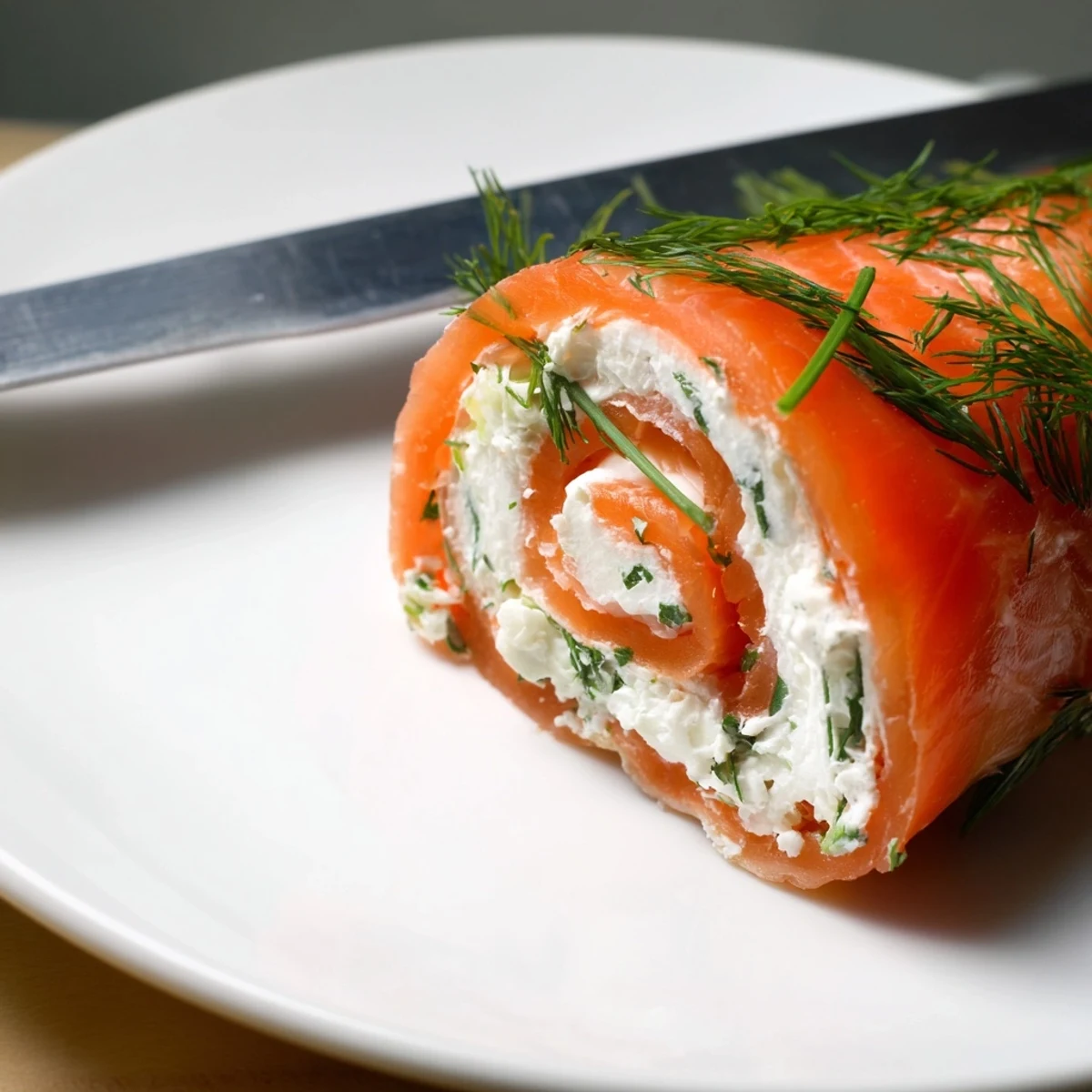 Fresh smoked salmon roll ups sliced into pinwheels revealing creamy herb and cheese layers on a white serving platter