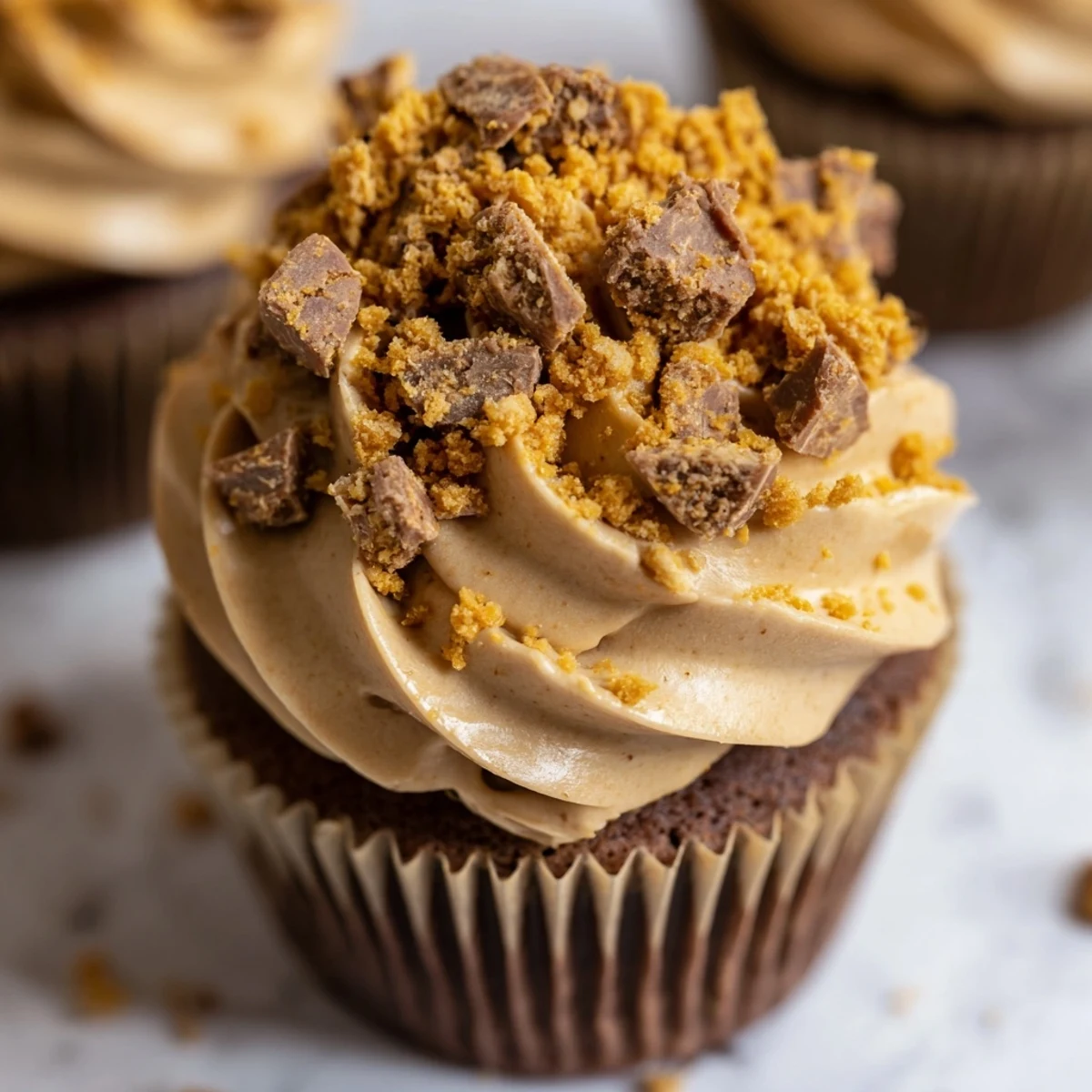 Rich chocolate cupcakes filled with creamy peanut butter and covered in Butterfinger buttercream frosting