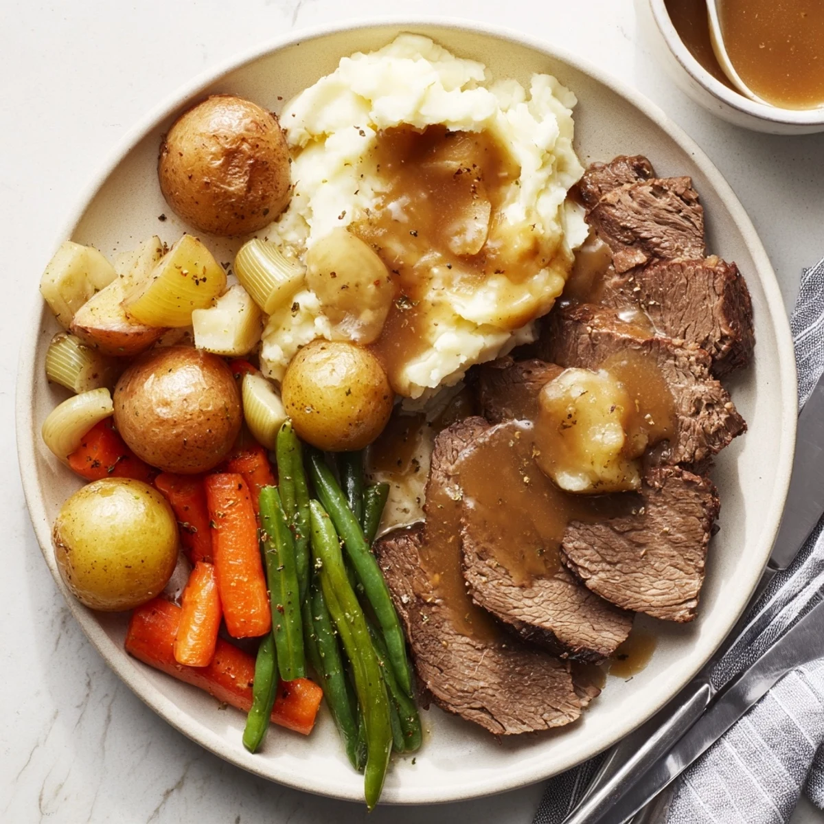 Slow-cooked Southern style pot roast glistening with dark gravy alongside velvety mashed potatoes and crisp green beans in this comforting Southern American dinner