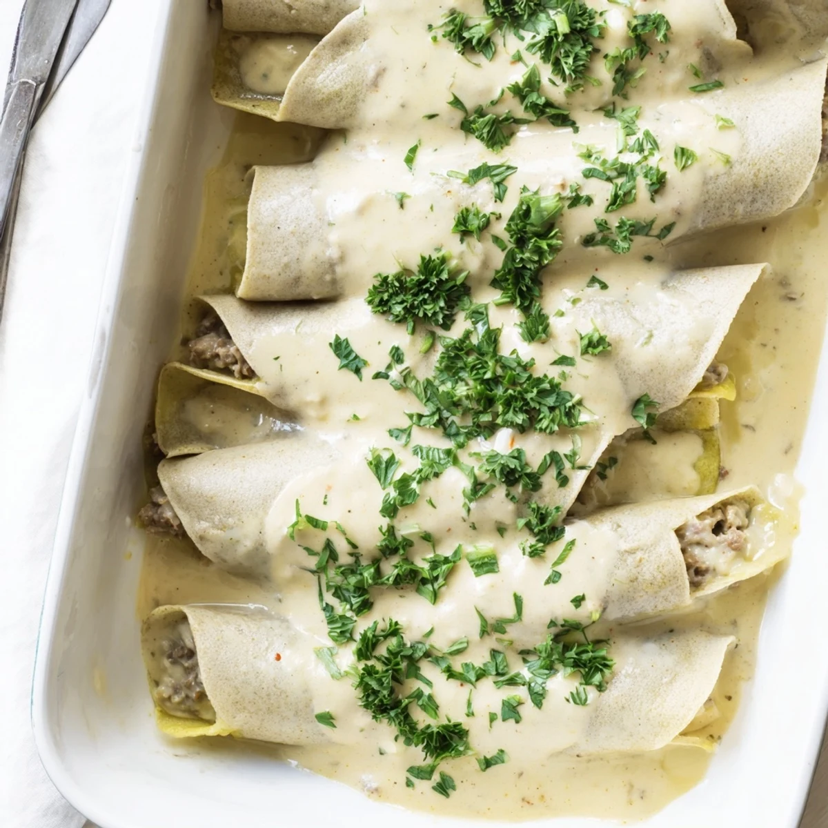 Baked Hungarian Hortobágyi palacsinta featuring tender crepes stuffed with spiced ground veal and topped with rich sauce