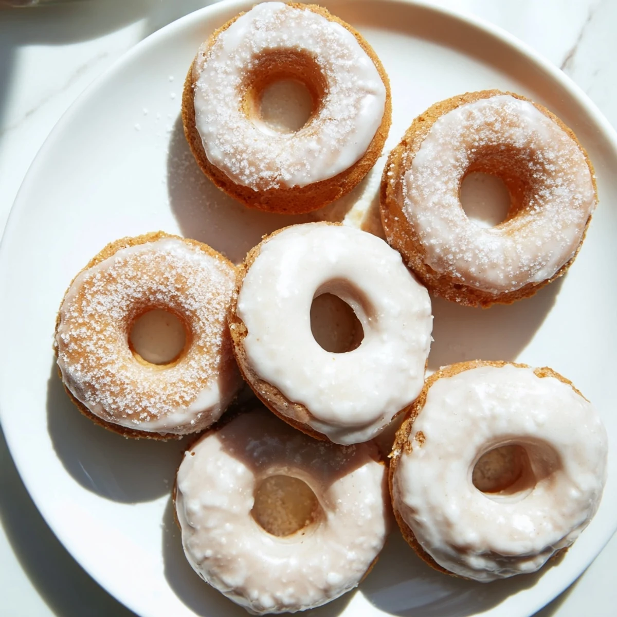 Freshly baked Greek yogurt cake donuts drizzled with white glaze and served on a rustic wooden board