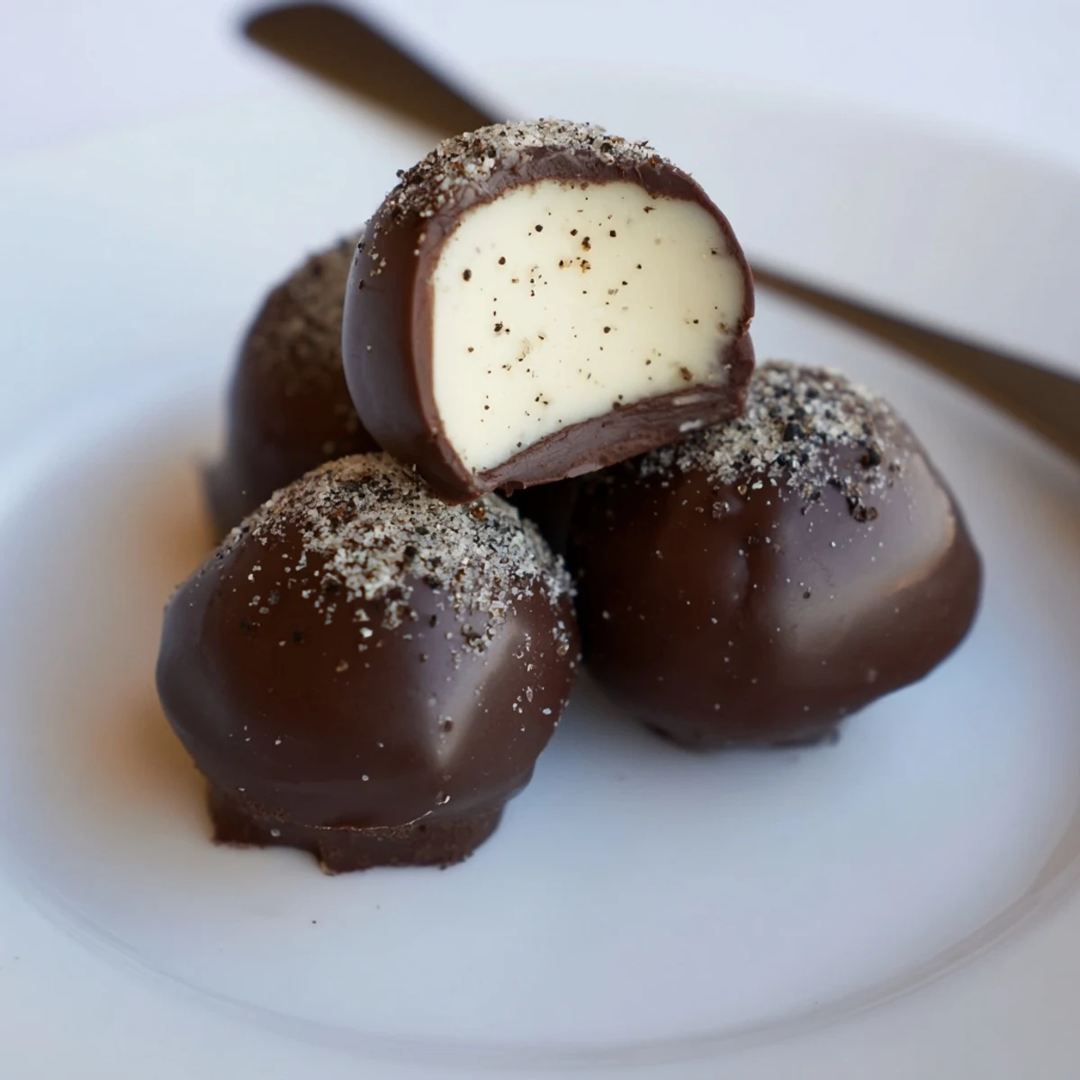 Hand-rolled Dark Chocolate Eggnog Truffles sit on parchment, ready to gift