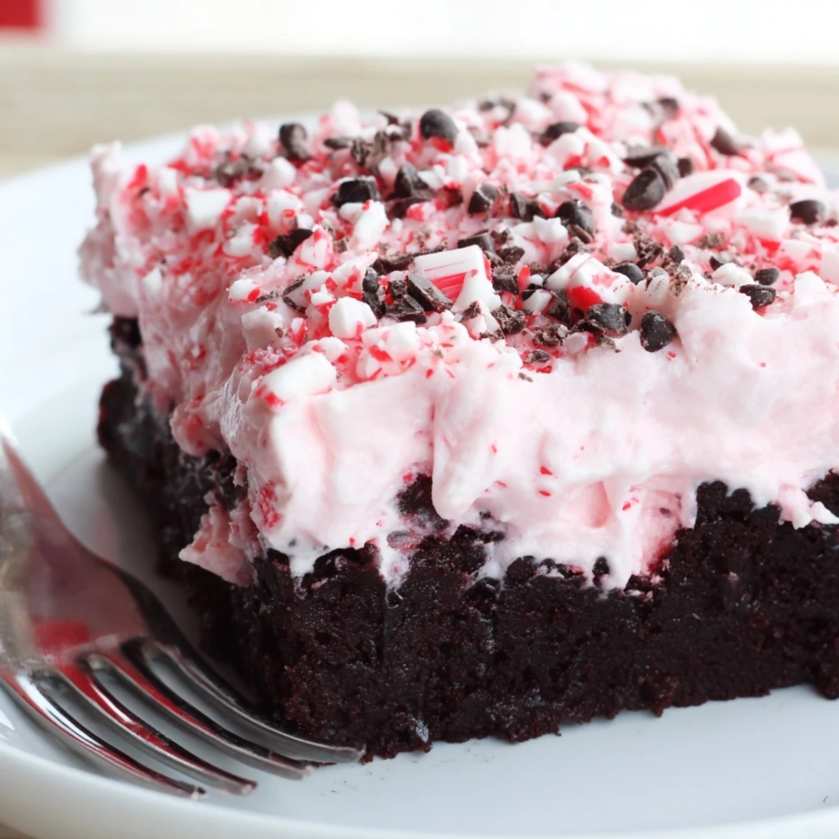 Holiday Peppermint Poke Cake on serving plate, minty aroma and chocolate shavings