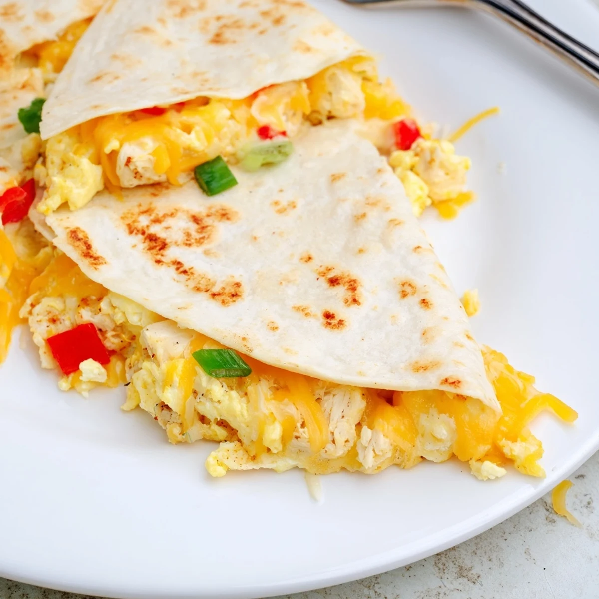 Close-up Chicken Breakfast Quesadilla wedge showing savory filling, crispy tortilla edges