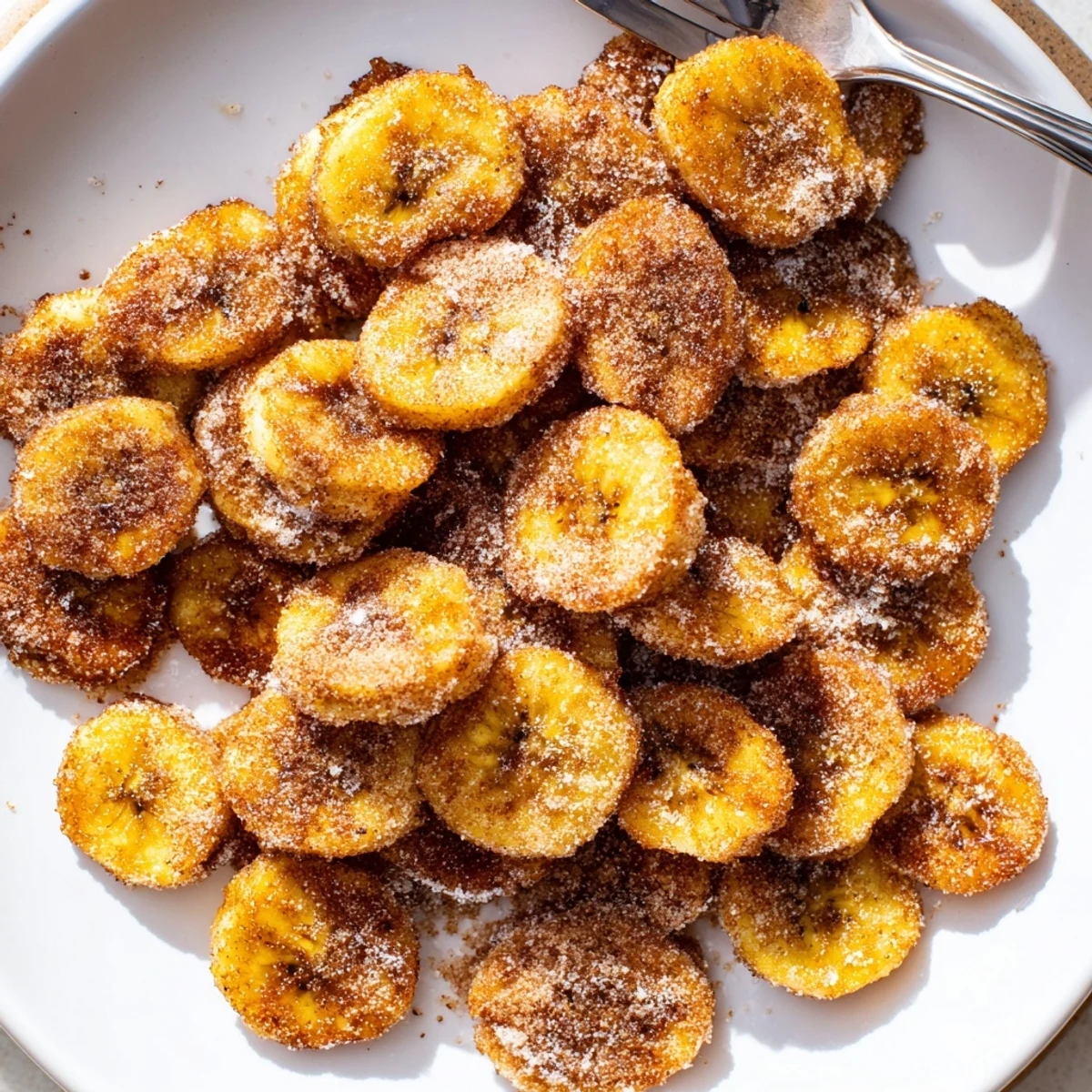 Crispy Cinnamon Sugar Air Fryer Banana Chips arranged on plate, warm and crunchy
