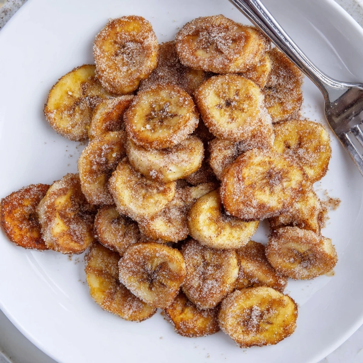 A bowl of Crispy Cinnamon Sugar Air Fryer Banana Chips, sugared, fragrant, snack-ready