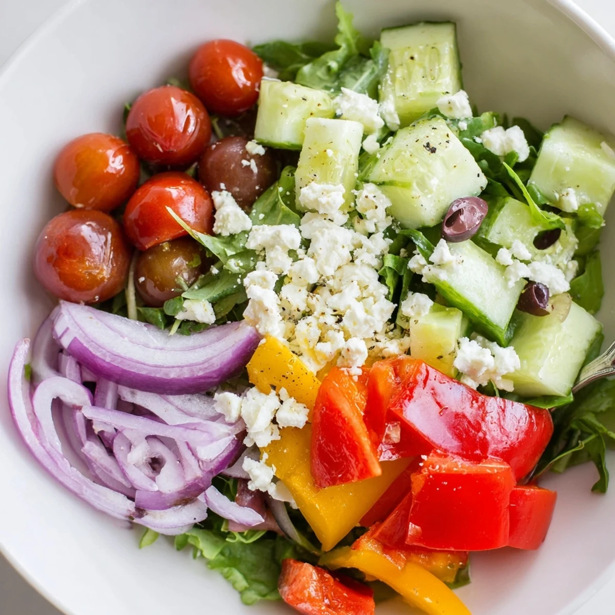 Bright bowl shows a Fresh Salad Recipe tossed in lemon-Dijon dressing.