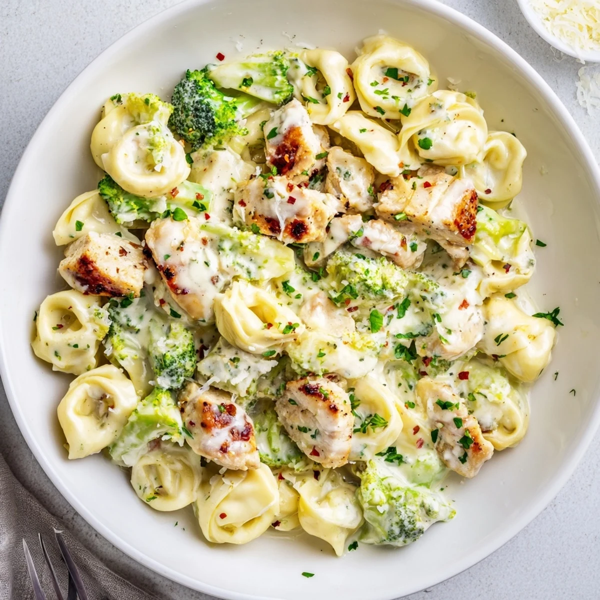 Steaming bowl of Creamy Garlic Parmesan Tortellini Chicken Broccoli Recipe, cheesy aroma