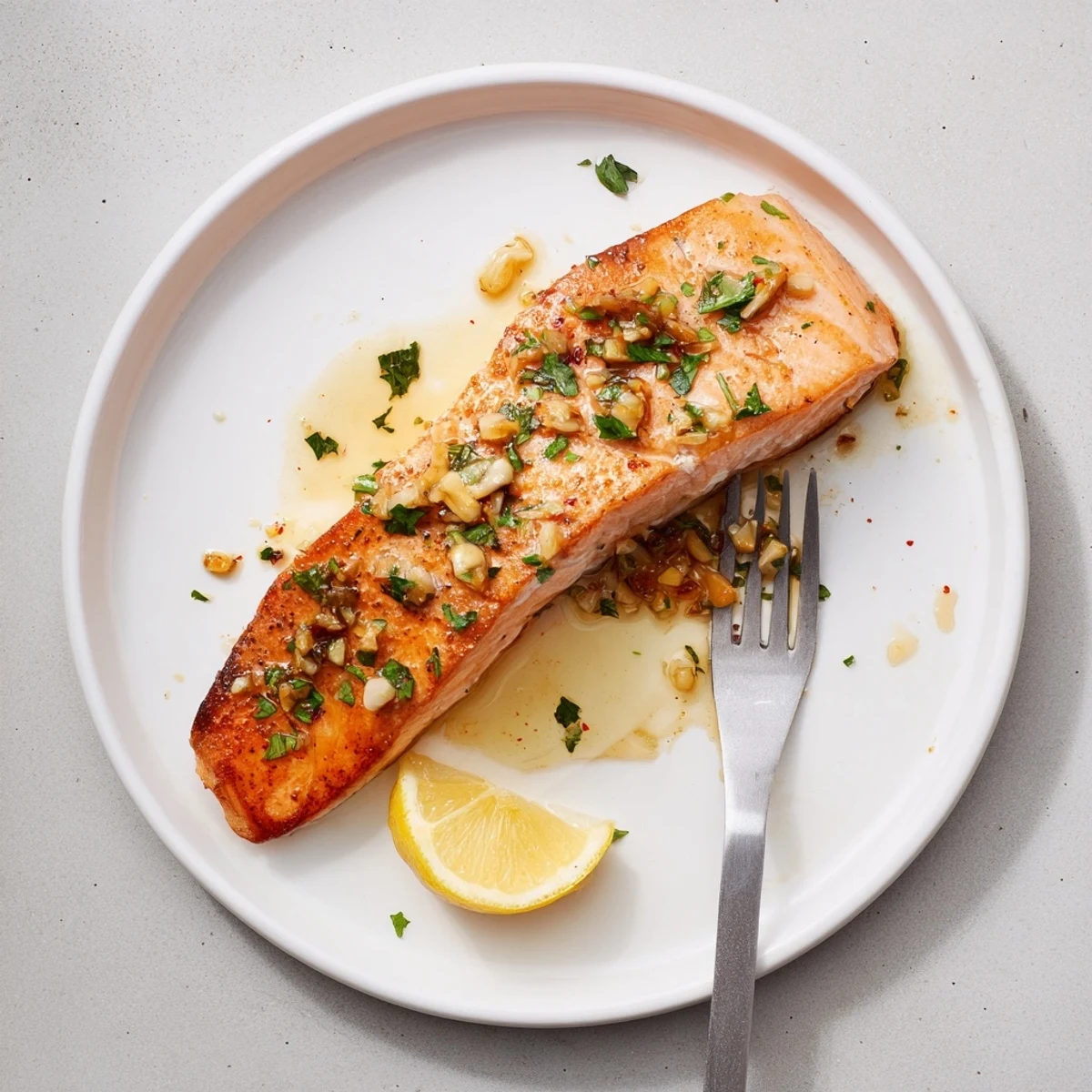 Golden pan seared salmon fillets with crispy skin glistening with melted garlic butter sauce