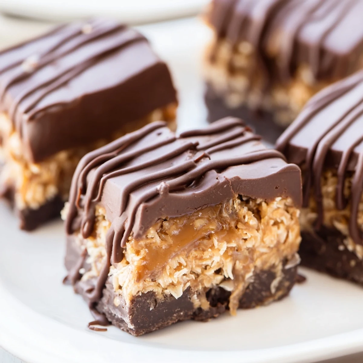 Close up of no bake Samoa bites showing gooey caramel layer and melted chocolate drizzle