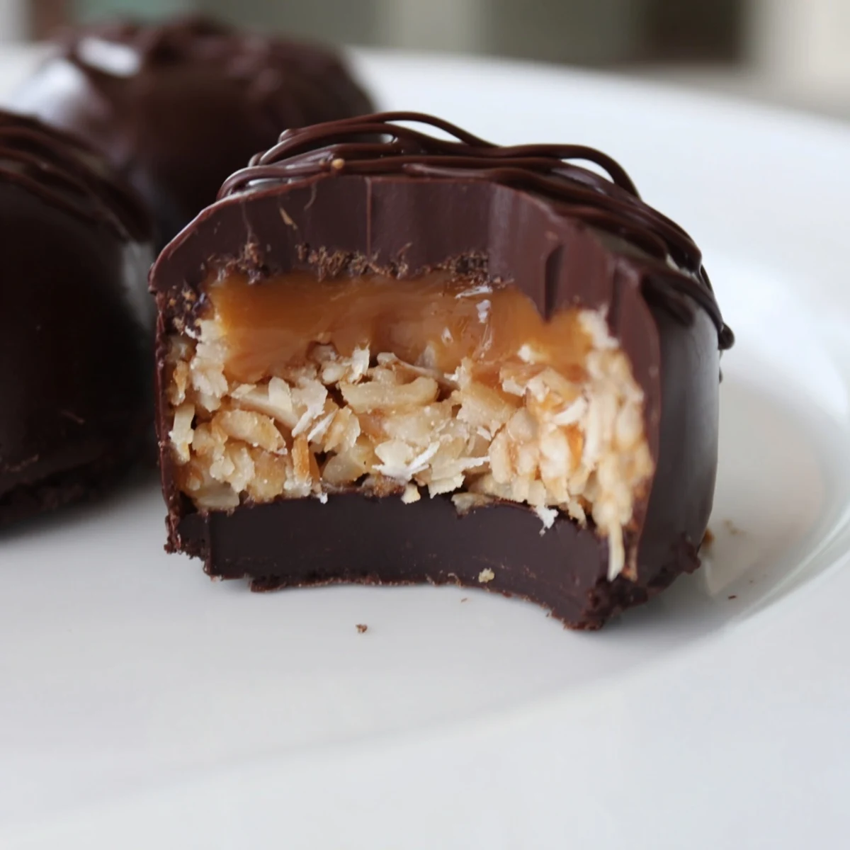 Chocolate dipped no bake Samoa bites with toasted coconut topping on parchment paper