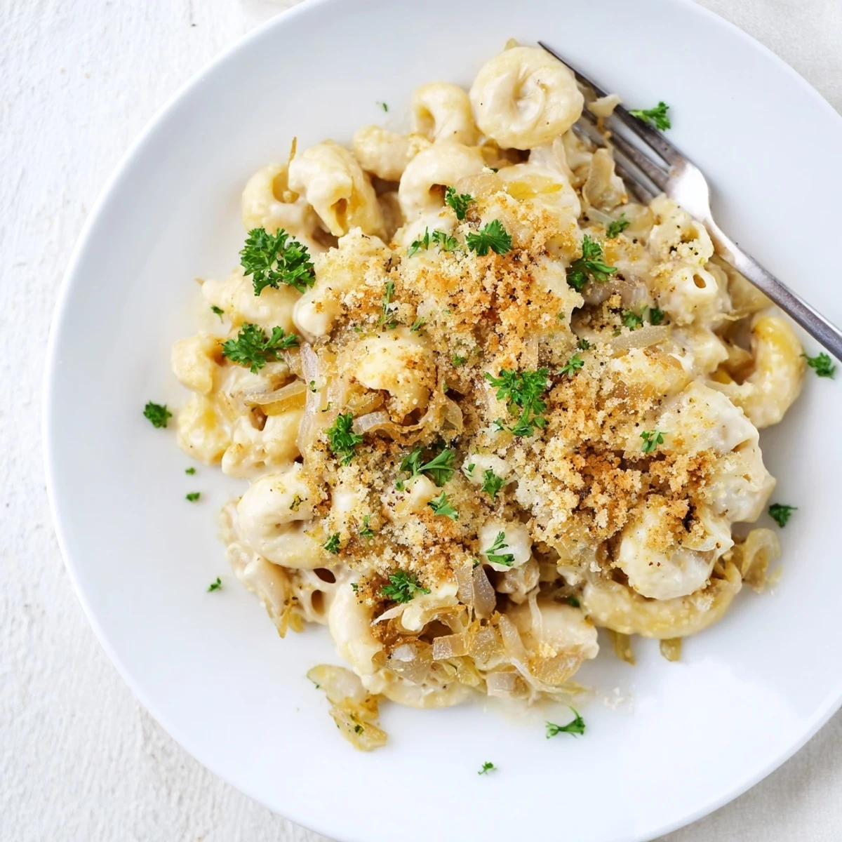 Golden brown French onion mac and cheese topped with crispy panko and fresh parsley garnish