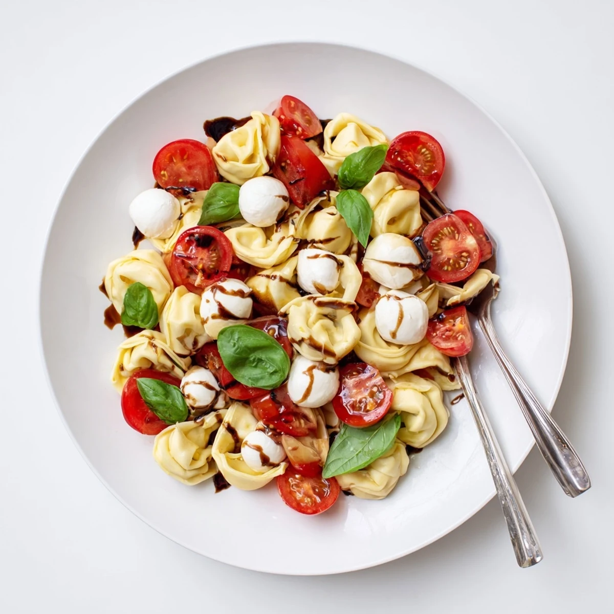 Fresh cheese tortellini tossed with juicy cherry tomatoes, basil, and mozzarella balls in a light Italian balsamic dressing