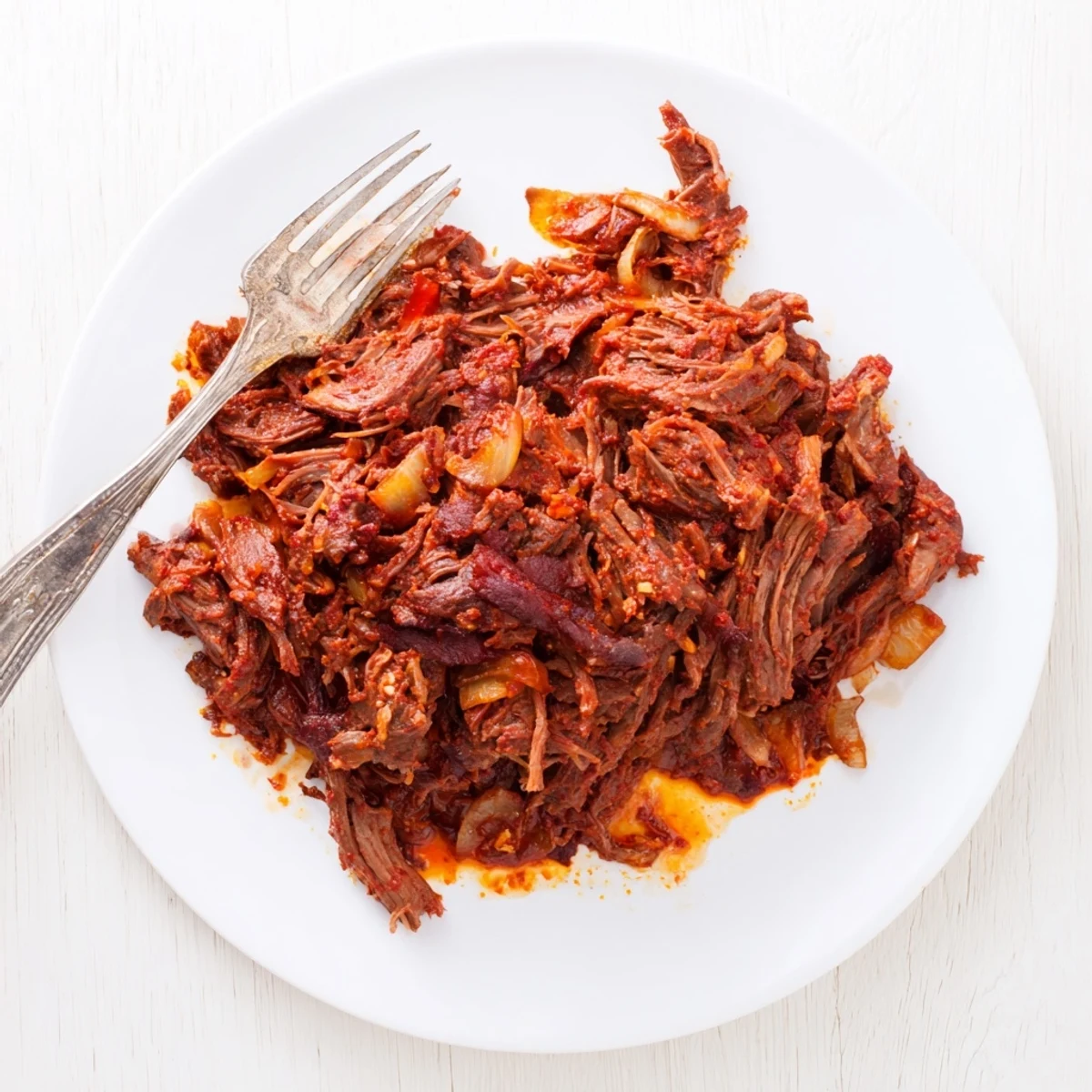 Tender slow cooker beef barbacoa shredded and served in a bowl with juicy bits