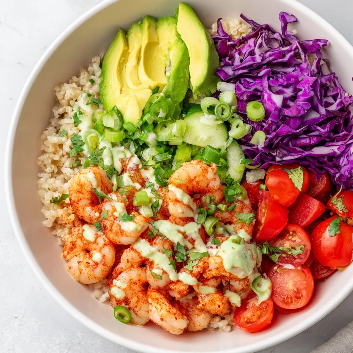 Golden seared shrimp grain bowl topped with crisp veggies and creamy avocado