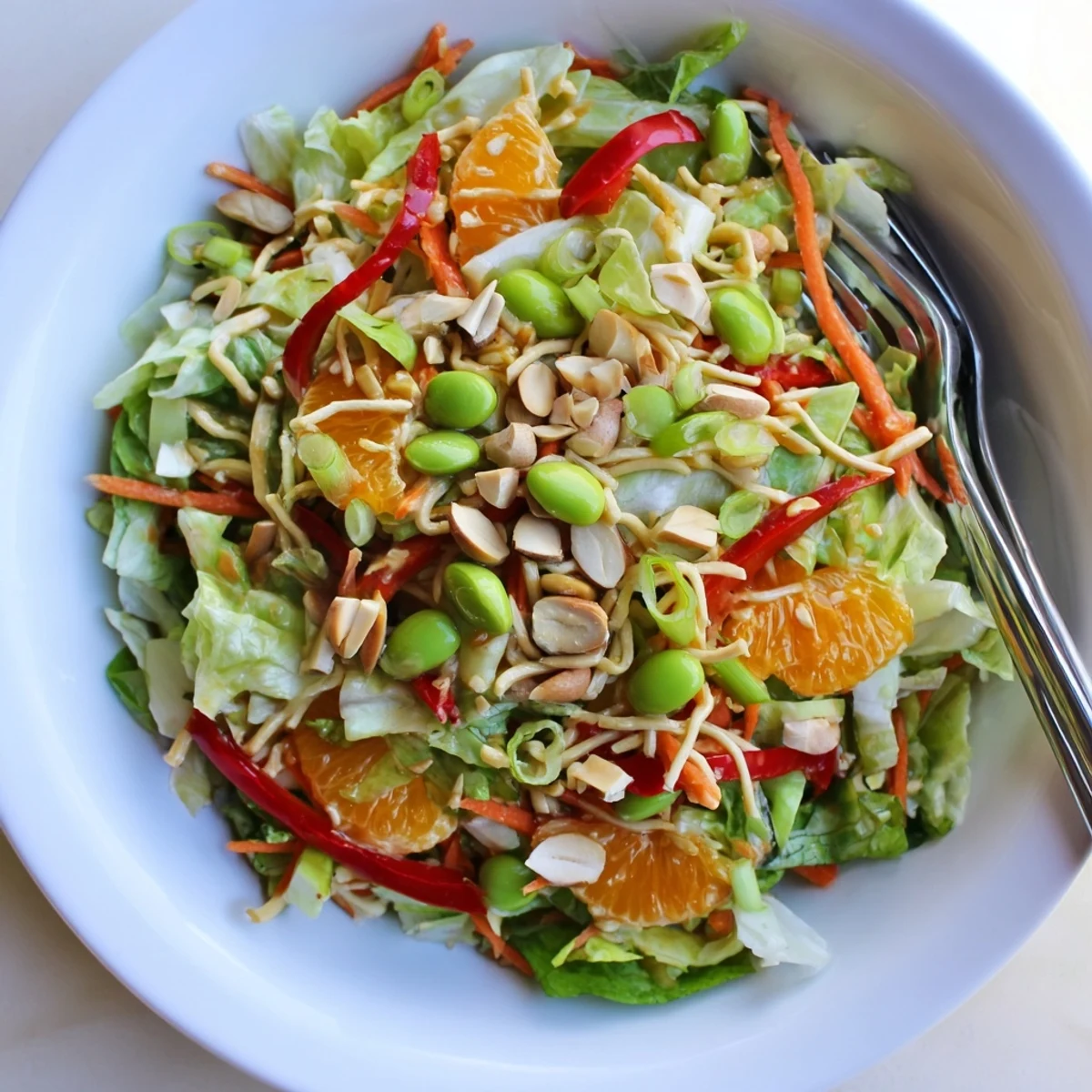 Mandarin Sesame Crunch Salad glistening with glossy dressing and bright orange segments