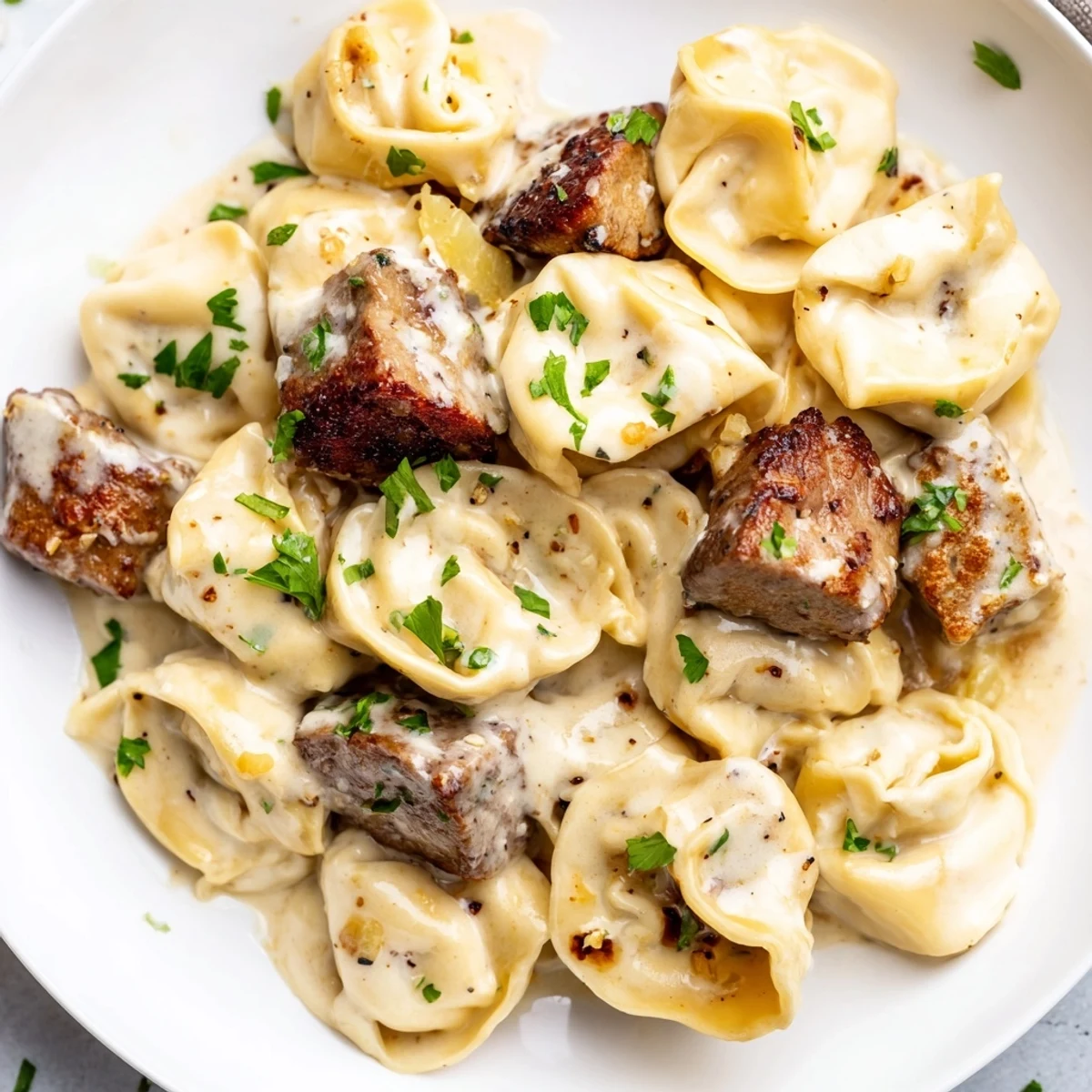 Creamy garlic steak tortellini in a golden Parmesan sauce topped with fresh parsley