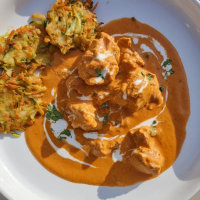 Buttery, spiced chicken simmered in rich tomato cream, served with crispy zucchini and carrot fritters for an indulgent main dish.