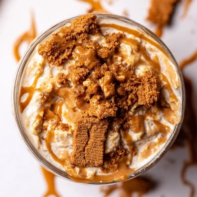 Quick Biscoff overnight oats swirled with caramel spread and finished with crunchy toppings