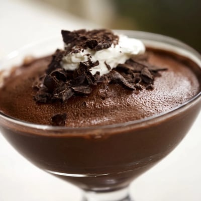 Silky chocolate mousse spooned into dessert cups with a dollop of whipped cream